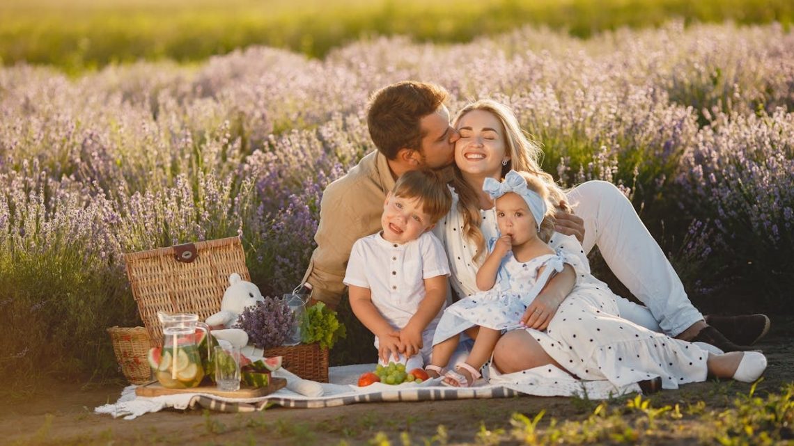 A joyful family enjoying a picnic together in a scenic lavender field during summer.
