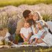 A joyful family enjoying a picnic together in a scenic lavender field during summer.